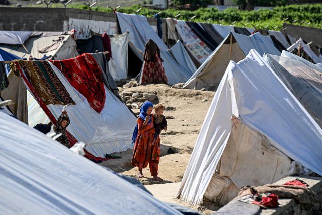 TOPSHOT - This photograph taken on April 12, 2026 shows Afghan internally displaced people, who have fled their homes due to the conflict between Pakistani forces and Taliban security personnel along the border, living in temporary tents on the outskirts of Kunar province. There are no children in the Afghan border village of Barikot, where the school has been smashed by shells and the playground sits deserted after weeks of war with Pakistan. More than 94,000 Afghans have been displaced by the war, OCHA figures show, more than a quarter of them in Kunar province. (Photo by Wakil KOHSAR / AFP)