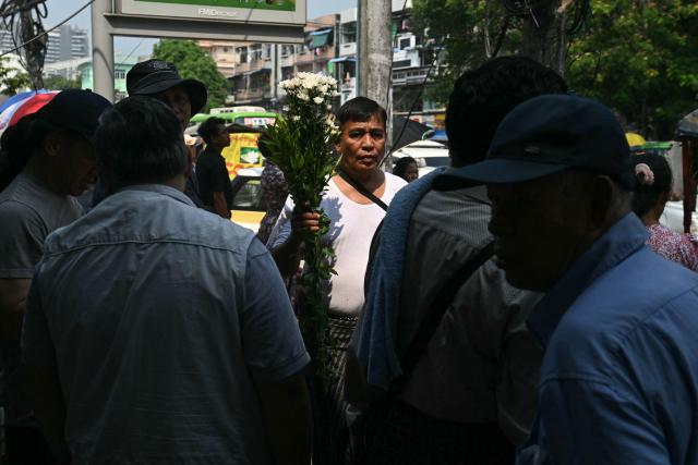 A man holds flowers as relatives wait outside Insein Prison for the release of prisoners as part of an amnesty to mark Myanmar's new year in Yangon on April 17, 2026. More than 4,300 prisoners were slated for release on April 17 to mark Myanmar's Thingyan new year, one of the country's many public holidays when forgiveness orders are regularly announced. (Photo by Sai Aung MAIN / AFP)