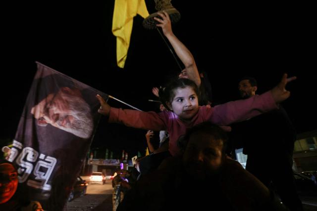 A Hezbollah supporter carrying a child on his shoulders celebrates a ceasefire with Israel in Sidon early on April 17, 2026. A 10-day ceasefire deal struck between Lebanon and Israel took effect on April 17, sending displaced residents streaming south towards their homes, even as the Lebanese army warned of "a number of violations" in the area. (Photo by MAHMOUD ZAYYAT / AFP)