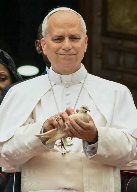 Pope Leo XIV (C) holds a white dove before releasing it after he met with the community of Bamenda at Saint Joseph's Cathedral in Bamenda, on the fourth day of an 11-day apostolic journey to Africa, on April 16, 2026. (Photo by Alberto PIZZOLI / AFP) / ALTERNATE CROP