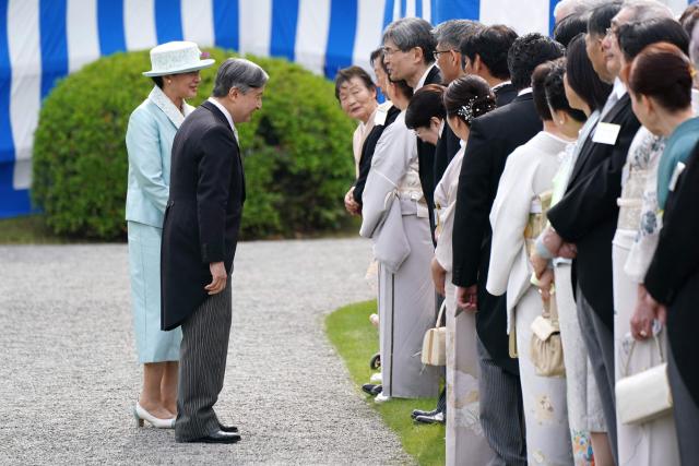 Japan's Emperor Naruhito (2nd L) and Empress Masako (L) greet guests during the spring garden party at the Akasaka Palace's imperial garden in Tokyo on April 17, 2026. (Photo by Kazuhiro NOGI / POOL / AFP)