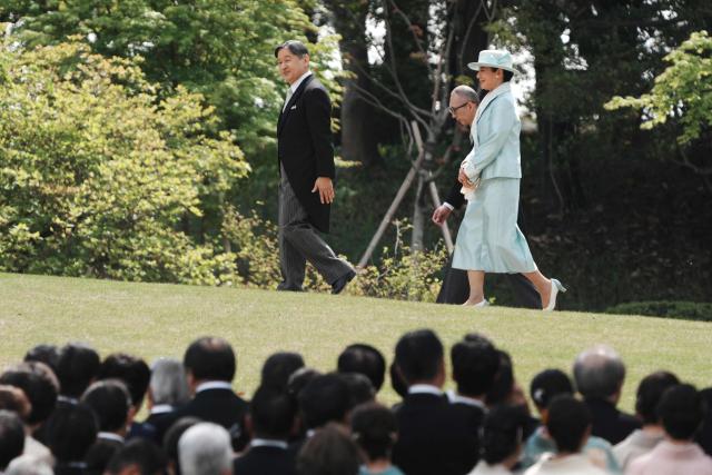 Japan's Emperor Naruhito (L) and Empress Masako (R) arrive to greet guests at a spring garden party at the Akasaka Palace's imperial garden in Tokyo on April 17, 2026. (Photo by Kazuhiro NOGI / POOL / AFP)