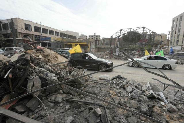 Displaced residents drive past a destroyed building as they return back to the southern Lebanese city of Nabatieh on April 17, 2026. A 10-day ceasefire deal struck between Lebanon and Israel took effect on April 17, sending displaced residents streaming south towards their homes, even as the Lebanese army warned of "a number of violations" in the area. (Photo by MAHMOUD ZAYYAT / AFP)