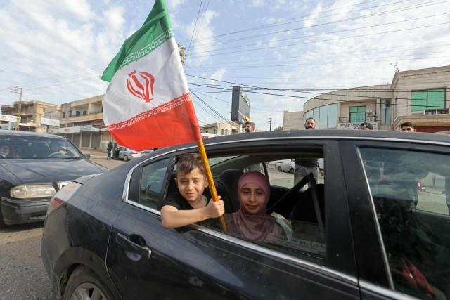 A boy holds an Iranian flag as he returns back to the southern Lebanese town of Marwanieh on April 17, 2026. A 10-day ceasefire deal struck between Lebanon and Israel took effect on April 17, sending displaced residents streaming south towards their homes, even as the Lebanese army warned of "a number of violations" in the area. (Photo by MAHMOUD ZAYYAT / AFP)