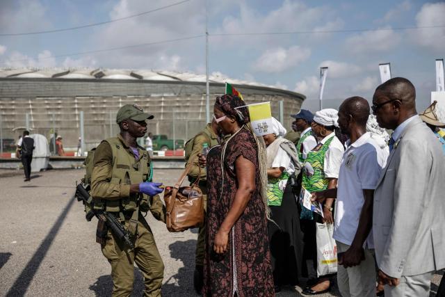 A Cameroonian soldier searches a woman's bag before she enters the venue ahead of the Holy Mass to be lead by Pope Leo XIV at the area in front of Japoma Stadium in Douala on the fifth day of an 11-day apostolic journey to Africa, on April 17, 2026. (Photo by Patrick MEINHARDT / AFP)