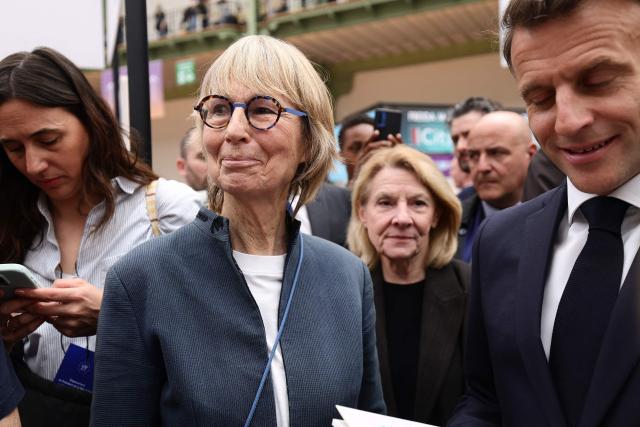 French President Emmanuel Macron (R) and former Actes Sud publishing house director and former culture minister Francoise Nyssen (L) visit the Paris Book Fair at the Grand Palais in Paris on April 17, 2026. The fair, which runs until April 19, spotlights comic books as its central theme. (Photo by Teresa SUAREZ / POOL / AFP)