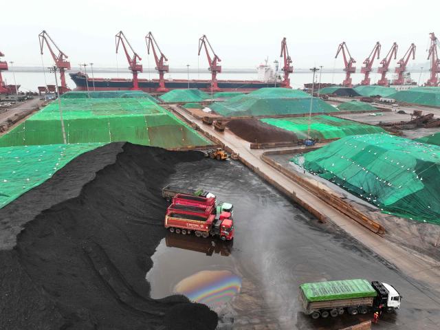 Lorries transport imported coal unloaded from cargo ships at the coal terminal in Lianyungang Port, in China’s eastern JIangsu province on April 17, 2026. (Photo by CN-STR / AFP) / China OUT