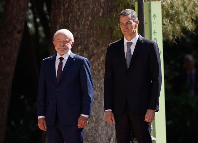 Spain's Prime Minister Pedro Sanchez (R) and Brazilian President Luiz Inacio Lula da Silva attend a military ceremony held to welcome the Brazilian President at the Palacio de Pedralbes in Barcelona on April 17, 2026. Lula meets Spanish Prime Minister Pedro Sanchez and is to attend a forum of progressive leaders on April 18. Other attendees at the gathering in Barcelona include Mexican President and South African President. (Photo by Oscar DEL POZO / AFP)