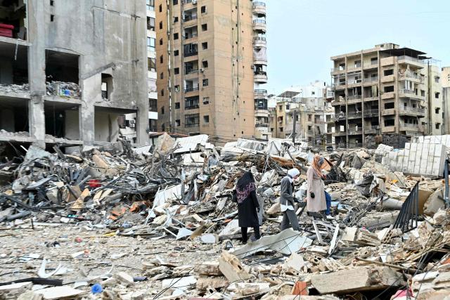 TOPSHOT - Lebanese women check destruction as they return to their neighbourhood in Beirut's southern suburbs after a 10-day ceasefire with Israel came into effect on April 17, 2026. A 10-day ceasefire deal struck between Lebanon and Israel took effect on April 17, sending displaced residents streaming south towards their homes, even as the Lebanese army warned of "a number of violations" in the area. (Photo by FADEL itani / AFP)