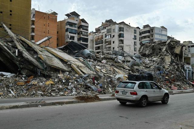 Lebanese residents returning to their neighbourhood drive past destruction in Beirut's southern suburbs after a 10-day ceasefire with Israel came into effect on April 17, 2026. A 10-day ceasefire deal struck between Lebanon and Israel took effect on April 17, sending displaced residents streaming south towards their homes, even as the Lebanese army warned of "a number of violations" in the area. (Photo by FADEL itani / AFP)