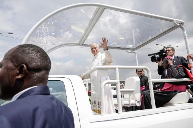 Pope Leo XIV (C) waves to the crowd from the Popemobile as he arrives to lead the Holy Mass at the area in front of Japoma Stadium in Douala on the fifth day of an 11-day apostolic journey to Africa, on April 17, 2026. (Photo by Patrick MEINHARDT / AFP)