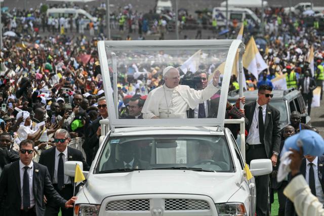 Pope Leo XIV (C) waves to the crowd from the Popemobile as he arrives to lead the Holy Mass at the area in front of Japoma Stadium in Douala on the fifth day of an 11-day apostolic journey to Africa, on April 17, 2026. (Photo by Alberto PIZZOLI / AFP)