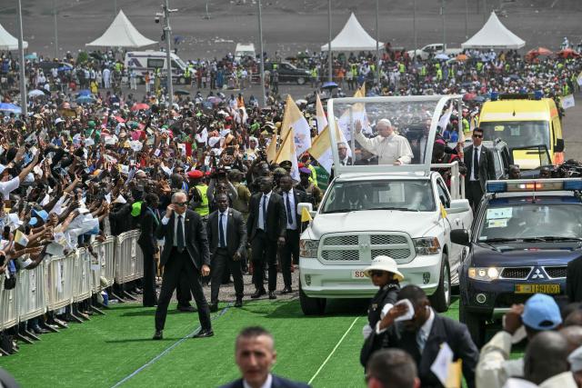 Pope Leo XIV (C) waves to the crowd from the Popemobile as he arrives to lead the Holy Mass at the area in front of Japoma Stadium in Douala on the fifth day of an 11-day apostolic journey to Africa, on April 17, 2026. (Photo by Alberto PIZZOLI / AFP)