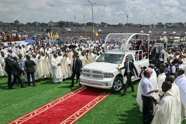 Pope Leo XIV (C) waves to the crowd from the Popemobile as he arrives to lead the Holy Mass at the area in front of Japoma Stadium in Douala on the fifth day of an 11-day apostolic journey to Africa, on April 17, 2026. (Photo by Alberto PIZZOLI / AFP)