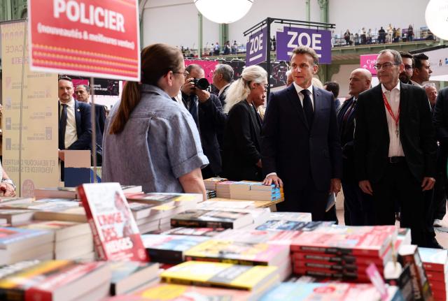 French President Emmanuel Macron visits the Paris Book Fair at the Grand Palais in Paris on April 17, 2026. The fair, which runs until April 19, spotlights comic books as its central theme. (Photo by Teresa SUAREZ / POOL / AFP)
