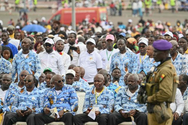 A Croonian soldier stands guard as faithfuls gather as Pope Leo XIV arrives to lead the Holy Mass at the area in front of Japoma Stadium in Douala on the fifth day of an 11-day apostolic journey to Africa, on April 17, 2026. (Photo by Alberto PIZZOLI / AFP)