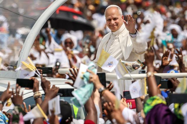 Pope Leo XIV waves to the crowd from the Popemobile as he arrives to lead the Holy Mass at the area in front of Japoma Stadium in Douala on the fifth day of an 11-day apostolic journey to Africa, on April 17, 2026. (Photo by Daniel Beloumou Olomo / AFP)
