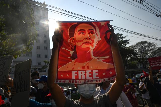 (FILES) A protester holds up a poster featuring Aung San Suu Kyi during a demonstration against the military coup in front of the Central Bank of Myanmar in Yangon on February 15, 2021. Myanmar's coup-ousted and detained democratic leader Aung San Suu Kyi had her sentence reduced as part of a mass amnesty on April 17, 2026, a source close to her legal case told AFP. (Photo by AFP)