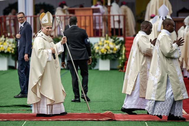 Pope Leo XIV (L) arrives to lead the Holy Mass at the area in front of Japoma Stadium in Douala on the fifth day of an 11-day apostolic journey to Africa, on April 17, 2026. (Photo by Patrick MEINHARDT / AFP)