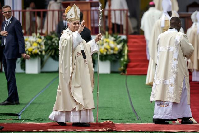 Pope Leo XIV (C) waves to the crowd as he arrives to lead the Holy Mass at the area in front of Japoma Stadium in Douala on the fifth day of an 11-day apostolic journey to Africa, on April 17, 2026. (Photo by Patrick MEINHARDT / AFP)