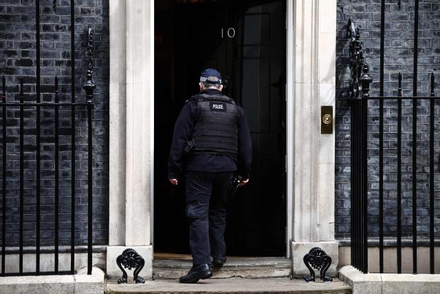 A Police officer enters the door to 10 Downing Street, the official residence of Britain's sitting Prime Minister, in Westminster in central London on April 17, 2026. UK Prime Minister Keir Starmer faced mounting pressure to quit on April l7, over his appointment of Peter Mandelson as envoy to Washington, after it emerged the veteran politician had failed security vetting. (Photo by Henry NICHOLLS / AFP)