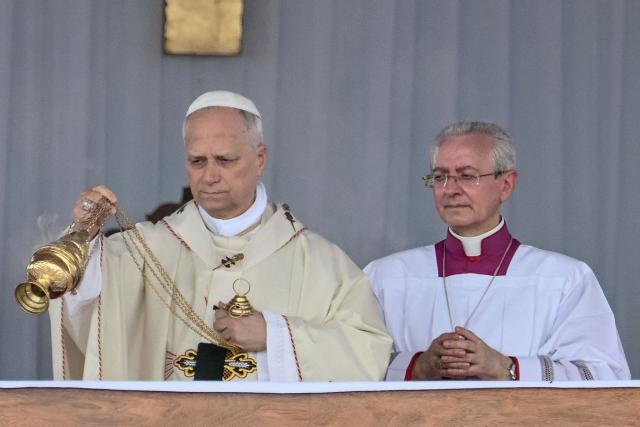 Pope Leo XIV (L) swings the thurible as he leads the Holy Mass at the area in front of Japoma Stadium in Douala on the fifth day of an 11-day apostolic journey to Africa, on April 17, 2026. (Photo by Alberto PIZZOLI / AFP)
