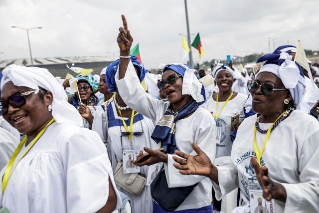 Supporters of Pope Leo XIV cheer as he arrives to lead the Holy Mass at the area in front of Japoma Stadium in Douala on the fifth day of an 11-day apostolic journey to Africa, on April 17, 2026. (Photo by Patrick MEINHARDT / AFP)