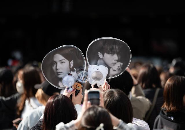 Fans of Korean boy band BTS take photos at Tokyo Dome before the start of the first BTS World Tour ‘Arirang’ in Tokyo on April 17, 2026. Tens of thousands of fans awaited excitedly outside the landmark Tokyo stadium to watch BTS in their first concert outside South Korea after the K-pop megastars kicked off their world tour. (Photo by Andrew CABALLERO-REYNOLDS / AFP)