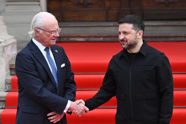 Ukraine's President Volodymyr Zelensky (R) greets Sweden's King Carl XVI Gustaf (L) prior to their talks in Lviv on April 17, 2026, amid the Russian invasion of Ukraine. (Photo by YURIY DYACHYSHYN / AFP)