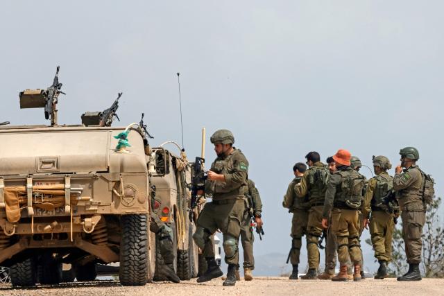 Israeli army soldiers stand next to their humvees as they patrol along the border with southern Lebanon, in the Upper Galilee of northern Israel on April 17, 2026. Israel's defence minister said on April 17 that the campaign against the militant group Hezbollah was not yet complete, just hours after a 10-day ceasefire came into force in Lebanon. (Photo by Jalaa MAREY / AFP)
