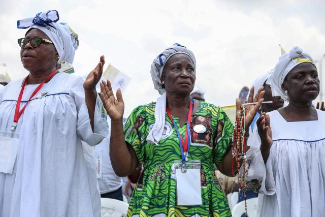 Faithfuls gesture as Pope Leo XIV leads the Holy Mass at the area in front of Japoma Stadium in Douala on the fifth day of an 11-day apostolic journey to Africa, on April 17, 2026. (Photo by Daniel Beloumou Olomo / AFP)