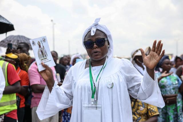 A faithful gestures as Pope Leo XIV leads the Holy Mass at the area in front of Japoma Stadium in Douala on the fifth day of an 11-day apostolic journey to Africa, on April 17, 2026. (Photo by Daniel Beloumou Olomo / AFP)