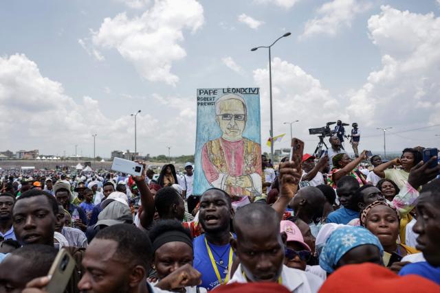 A Faithful holds up a placard with the image of Pope Leo XIV on while the Pope leads the Holy Mass at the area in front of Japoma Stadium in Douala on the fifth day of an 11-day apostolic journey to Africa, on April 17, 2026. (Photo by Patrick MEINHARDT / AFP)
