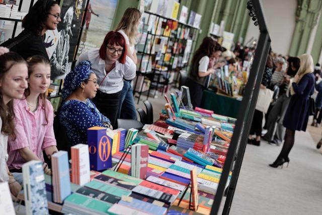 Participants present books at the Paris Book Fair at the Grand Palais in Paris on April 17, 2026. The fair, which runs until April 19, spotlights comic books as its central theme. (Photo by STEPHANE DE SAKUTIN / AFP)
