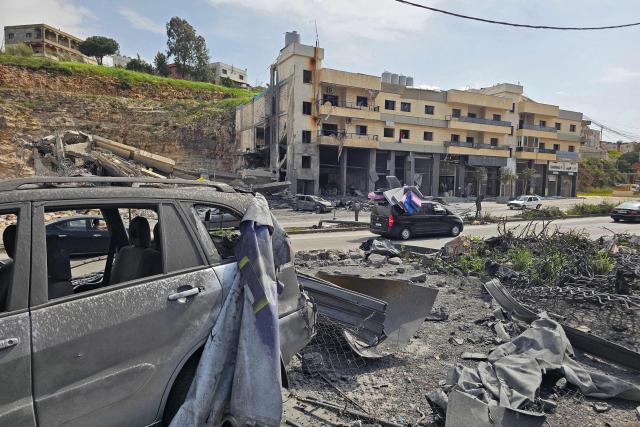 Displaced residents drive past damaged cars and buildings as they travel back to their homes in the southern Lebanese city of Nabatieh on April 17, 2026. Thousands of displaced Lebanese civilians took to the road on April 17, hoping that a 10-day ceasefire with Israel would allow them to return to their homes in southern Beirut and the country's war-torn south. (Photo by AFP)