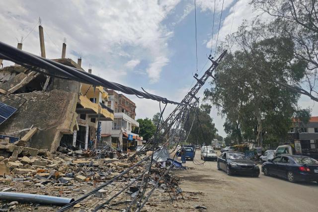 Displaced residents drive past damaged buildings as they travel back to their homes in the southern Lebanese city of Nabatieh on April 17, 2026. Thousands of displaced Lebanese civilians took to the road on April 17, hoping that a 10-day ceasefire with Israel would allow them to return to their homes in southern Beirut and the country's war-torn south. (Photo by AFP)