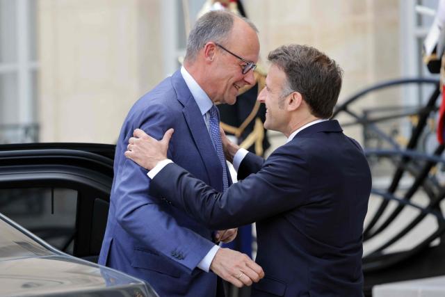 France's President Emmanuel Macron (R) welcomes German chancellor Friedrich Merz ahead of a meeting of allies to consider sending a multinational force to ensure security and free-flowing trade in the Strait of Hormuz, at the presidential Elysee Palace in Paris on April 17, 2026. French President Emmanuel Macron and UK Prime Minister Keir Starmer chair a meeting of allies to consider sending a multinational force to ensure security and free-flowing trade in the Strait of Hormuz once the current conflict between Iran and the US and Israel ends. Iran imposed the blockade on the critical shipping bottleneck as soon as the US and Israel launched the war against the Islamic republic on February 28, leading to a surge in global energy prices. Even with a shaky ceasefire in place, the US is now imposing its own blockade on Iranian ports. (Photo by Ludovic MARIN / AFP)