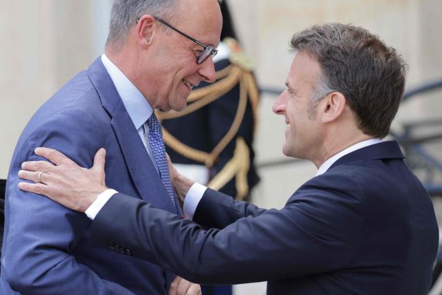 France's President Emmanuel Macron (R) welcomes German chancellor Friedrich Merz ahead of a meeting of allies to consider sending a multinational force to ensure security and free-flowing trade in the Strait of Hormuz, at the presidential Elysee Palace in Paris on April 17, 2026. French President Emmanuel Macron and UK Prime Minister Keir Starmer chair a meeting of allies to consider sending a multinational force to ensure security and free-flowing trade in the Strait of Hormuz once the current conflict between Iran and the US and Israel ends. Iran imposed the blockade on the critical shipping bottleneck as soon as the US and Israel launched the war against the Islamic republic on February 28, leading to a surge in global energy prices. Even with a shaky ceasefire in place, the US is now imposing its own blockade on Iranian ports. (Photo by Ludovic MARIN / AFP)