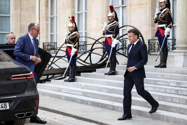 France's President Emmanuel Macron (R) welcomes Germany's Chancellor Friedrich Merz (L) ahead of a meeting of allies to consider sending a multinational force to ensure security and free-flowing trade in the Strait of Hormuz, at the presidential Elysee Palace in Paris on April 17, 2026. French President Emmanuel Macron and UK Prime Minister Keir Starmer chair a meeting of allies to consider sending a multinational force to ensure security and free-flowing trade in the Strait of Hormuz once the current conflict between Iran and the US and Israel ends. Iran imposed the blockade on the critical shipping bottleneck as soon as the US and Israel launched the war against the Islamic republic on February 28, leading to a surge in global energy prices. Even with a shaky ceasefire in place, the US is now imposing its own blockade on Iranian ports. (Photo by Tom Nicholson / POOL / AFP)