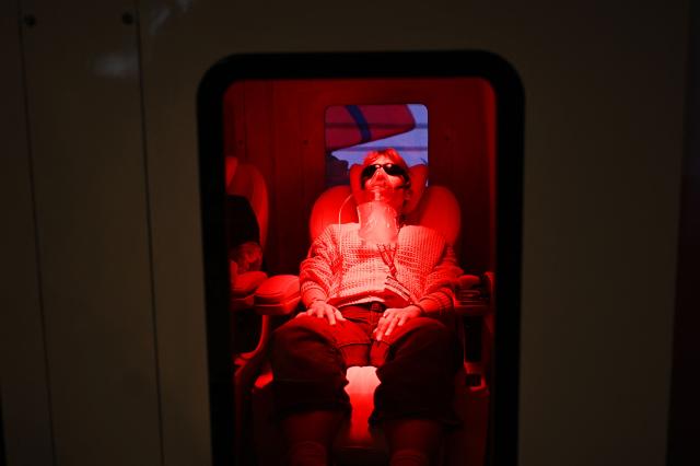 A woman lies in a Oxygen chamber at thr x4oxygen booth at the FIBO trade show for health, fitness and wellness in Cologne, western Germany on April 17, 2026. (Photo by Ina FASSBENDER / AFP)