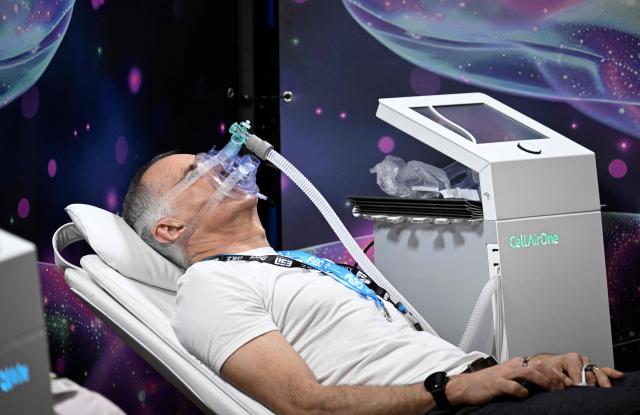 A man uses a mask of CellAirOne, which simulates altitude training at the FIBO trade show for health, fitness and wellness in Cologne, western Germany on April 17, 2026. (Photo by Ina FASSBENDER / AFP)