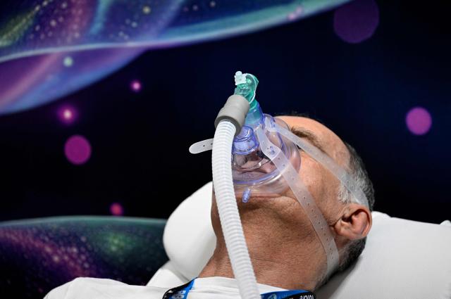 A man uses a mask of CellAirOne, which simulates altitude training at the FIBO trade show for health, fitness and wellness in Cologne, western Germany on April 17, 2026. (Photo by Ina FASSBENDER / AFP)