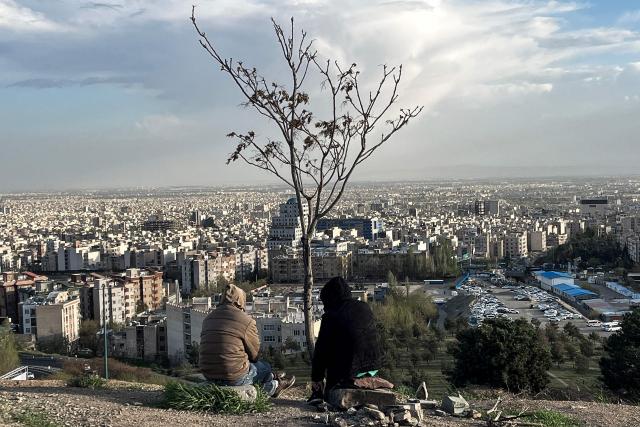 TOPSHOT - People sit overlooking the city at Pardisan Park in Tehran on April 14, 2026. Iran's foreign ministry welcomed the truce agreed between Israel and Lebanon, calling it part of the earlier two-week ceasefire deal struck between the Islamic republic and the United States to pause the Middle East war, state media reported. (Photo by AFP)