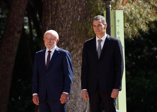 Spain's Prime Minister Pedro Sanchez (R) and Brazilian President Luiz Inacio Lula da Silva attend a military ceremony held to welcome the Brazilian President at the Palacio de Pedralbes in Barcelona on April 17, 2026. Lula meets Spanish Prime Minister Pedro Sanchez and is to attend a forum of progressive leaders on April 18. Other attendees at the gathering in Barcelona include Mexican President and South African President. (Photo by Oscar DEL POZO / AFP)