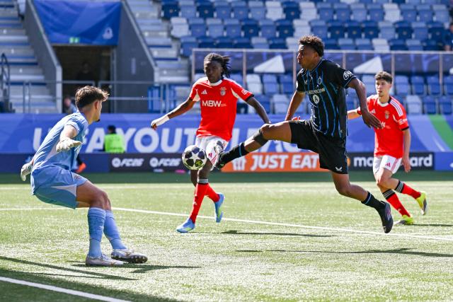 Club Brugge's Belgian forward #99 Yanis Musuayi scores his team's third goal against SL Benfica's Portugese goalkeeper #1 Diogo Ferreira during the UEFA Youth League semi-final football match between Benfica and Club Brugge at Stade de la Tuiliere in Lausanne, on April 17, 2026. (Photo by Fabrice COFFRINI / AFP)