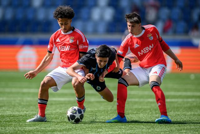 Club Brugge's Belgian midfielder #68 Utku Kurtal (C) fall between SL Benfica's Portugese defender #13 Duarte Soares (L) and SL Benfica's Portugese forward #17 Eduardo Fernandes during the UEFA Youth League semi-final football match between Benfica and Club Brugge at Stade de la Tuiliere in Lausanne, on April 17, 2026. (Photo by Fabrice COFFRINI / AFP)