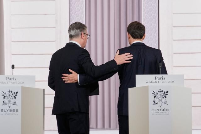 British Prime Minister Keir Starmer (L) and French President Emmanuel Macron (R) embrace following a joint statement at the end of an international summit on efforts to reopen the Strait of Hormuz at the Elysee Palace in Paris on April 17, 2026. French President Emmanuel Macron and UK Prime Minister Keir Starmer chair a meeting of allies to consider sending a multinational force to ensure security and free-flowing trade in the Strait of Hormuz once the current conflict between Iran and the US and Israel ends. Iran imposed the blockade on the critical shipping bottleneck as soon as the US and Israel launched the war against the Islamic republic on February 28, leading to a surge in global energy prices. Even with a shaky ceasefire in place, the US is now imposing its own blockade on Iranian ports. (Photo by Michel Euler / POOL / AFP)