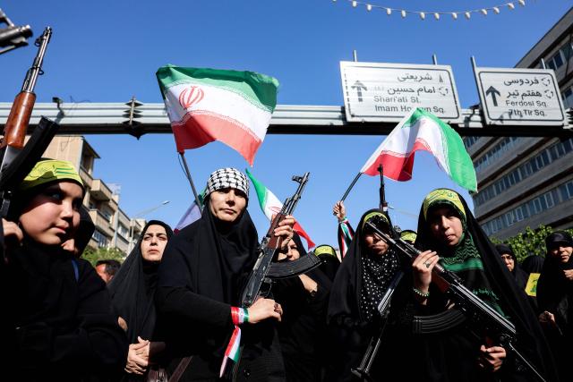 TOPSHOT - Iranian women brandish their rifles as they take part in a rally dubbed “Sacrificed Girls” to pay tribute to women killed during the Middle East war in Tehran on April 17, 2026. On February 28, Israel and the United States launched strikes on Iran killing its supreme leader and triggering a war that spread across the Middle East and unleashed chaos across global markets and sent oil prices soaring. (Photo by AFP) / 