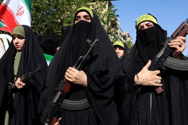 Iranian women brandish their rifles as they take part in a rally dubbed “Sacrificed Girls” to pay tribute to women killed during the Middle East war in Tehran on April 17, 2026. On February 28, Israel and the United States launched strikes on Iran killing its supreme leader and triggering a war that spread across the Middle East and unleashed chaos across global markets and sent oil prices soaring. (Photo by AFP) / 