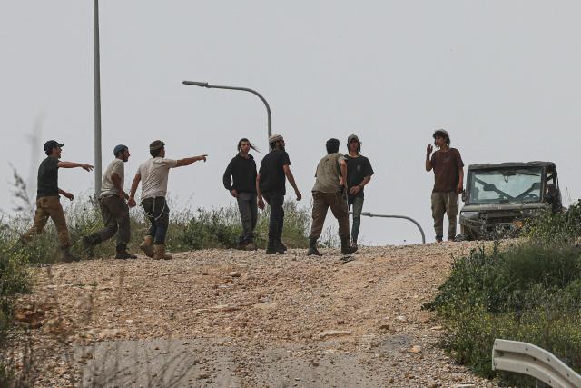 Israeli settlers  leave the area after reportedly attacking local Palestinian farmers working on their land, spraying them with pepper spray, near the village of Halhoul, south of the Israel-occupied West Bank city of Hebron, on April 17, 2026. (Photo by HAZEM BADER / AFP)